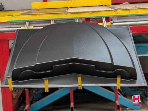 schwarzes großes Kunststoffgehäuse auf Thermoformmaschine nach Tiefziehen